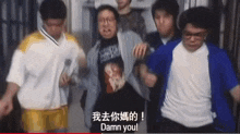 a group of people are standing around a man who is wearing a shirt that says damn you