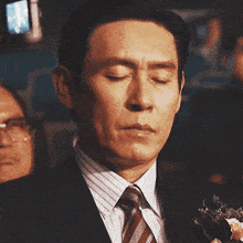 a man in a suit and tie has a flower in his pocket