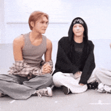 a group of people are sitting on the ground looking at each other