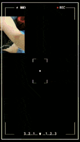 a woman taking a selfie with a rec button on the bottom left