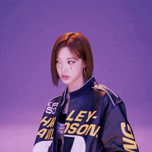 a woman wearing a harley davidson jacket with a purple background
