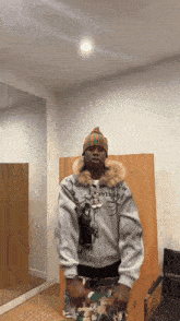 a man wearing a beanie and a jacket that says ' supreme ' on it is standing in front of a mirror