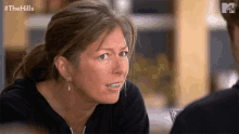 a woman with a ponytail looks at a man with a mtv logo in the background