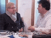 a man in a suit and scarf is talking to another man with the words stick it down then written below him