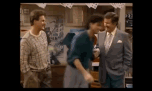 a group of men are standing next to each other in a room talking to each other .