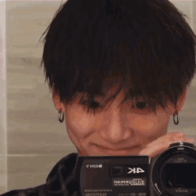 a young man taking a picture with a camera that says 4k