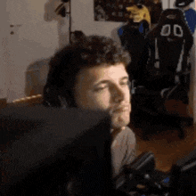 a man is sitting in front of a computer monitor .