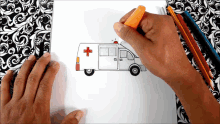 a person is drawing an ambulance with a red cross on it