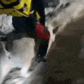 a person is walking down a snowy hill with a yellow backpack .