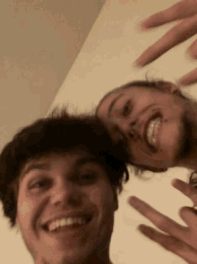 two men are posing for a picture together and smiling .