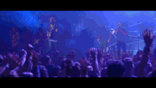 a crowd at a concert with their hands up