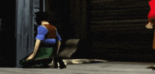 a man in a blue shirt is doing a handstand in front of a wooden wall .