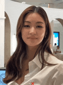 a woman wearing a white shirt with the word no x written on it