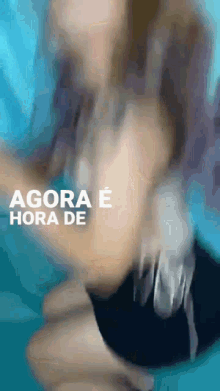 a blurry picture of a woman with the words agora e hora de on the bottom right
