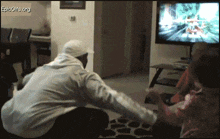 a man is squatting down in front of an epicgifs.org screen