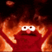 elmo from sesame street is in the middle of a fire .