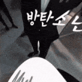 a man in a suit is standing in front of a sign that says ' korean '