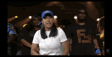 a woman in a white shirt stands in front of a group of people with the real rap sheet written on the bottom