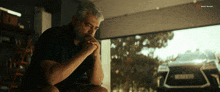 a man is sitting in front of a car with a license plate that says s7rb72