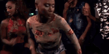 a woman is dancing in front of a crowd of people in a nightclub .