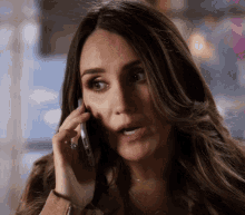 a woman talking on a cell phone with a ring on her finger