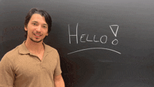 a man is standing in front of a blackboard that says hello