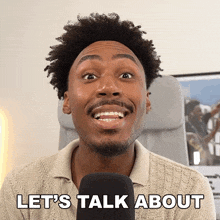 a man is talking into a microphone with the words let 's talk about above him