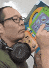 a man wearing headphones is holding a toy that says ' animals ' on it