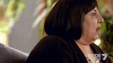 a woman is sitting on a couch with her mouth open and the word bride is on the bottom of the screen .