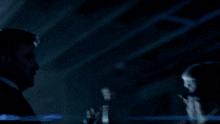 a man and a woman are standing next to each other in the dark