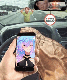 a person holding a cell phone with a i love my femboy sticker on the rear view mirror