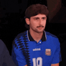 a man wearing a blue shirt with the number 10 on it is making a funny face .