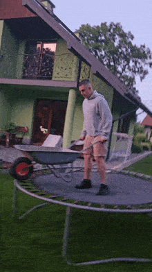 a man pushing a wheelbarrow on a trampoline