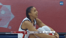 a female basketball player sits on the bench during a game between fdu and uconn