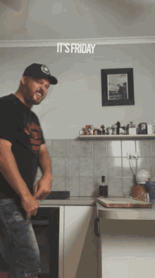 a man is dancing in a kitchen with the words it 's friday written above him