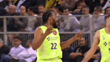 a basketball player with the number 22 on his jersey points