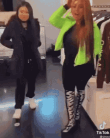 two women are standing next to each other in a clothing store .