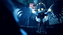 a robot with wings is standing in a dark room holding a camera .