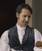 a man in a plaid vest and white shirt