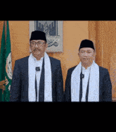 two men are standing next to each other in front of a green flag and a picture of a leaf