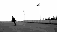 a person riding a skateboard in a parking lot with street lights in the background