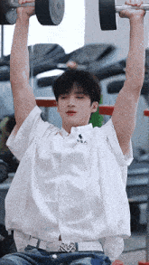 a young man is lifting a dumbbell in a gym