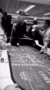 a group of people are playing a game of craps at a casino