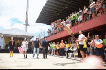 a group of people are gathered in front of a red building