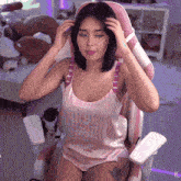 a woman is sitting in a pink and white chair with the letters xg on the bottom