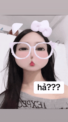 a girl wearing glasses and a bow on her head has a question mark above her head