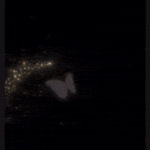 a woman in a black dress is surrounded by sparkles