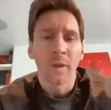 a close up of a man 's face making a funny face while talking on a video call .