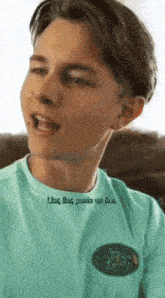 a young man wearing a blue shirt that says ' live like pants on fire ' on it
