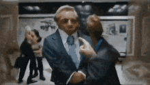 a man in a suit and tie is pointing at someone